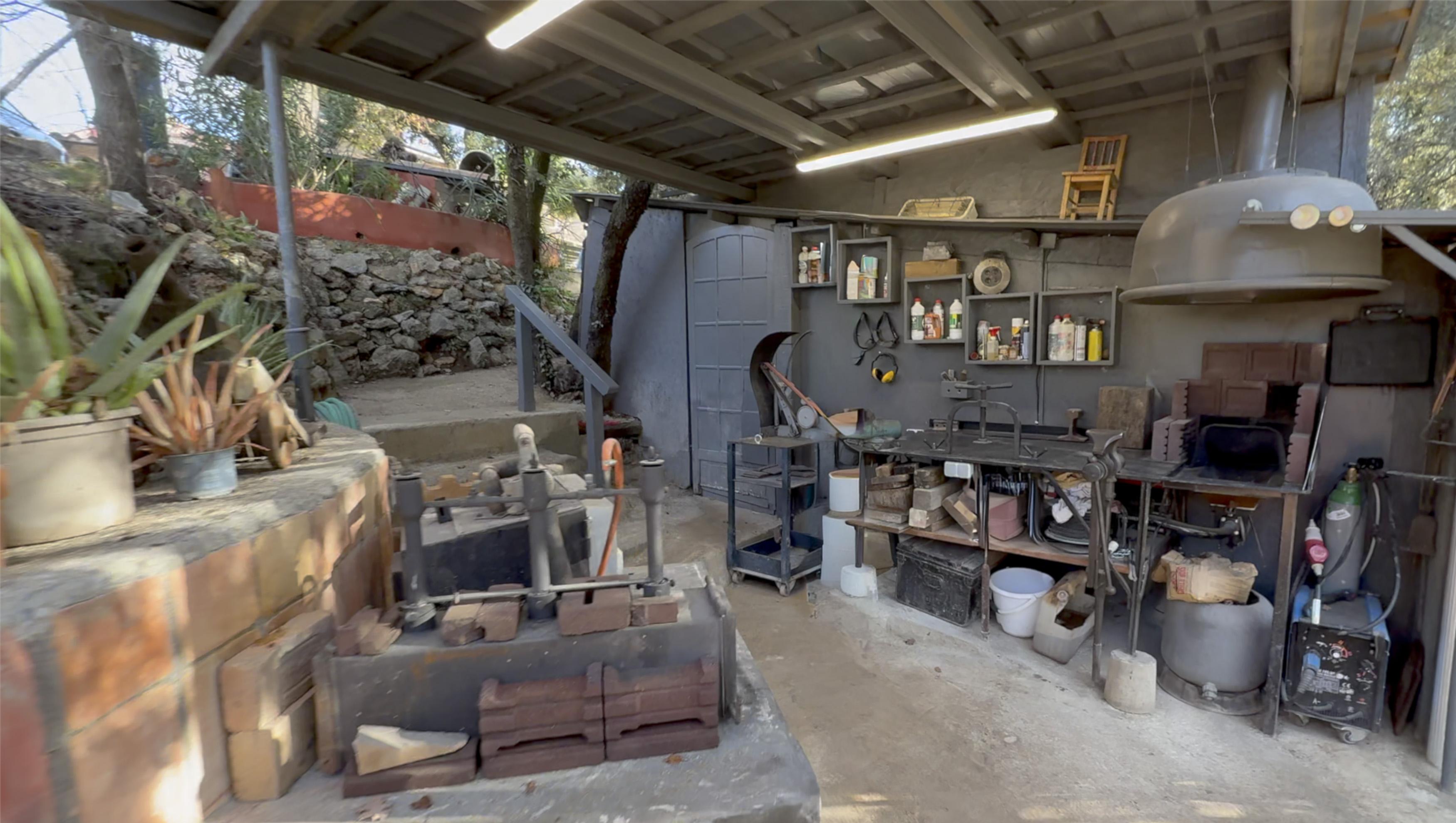 Forge, anvil and grinding station with a view of the hills
